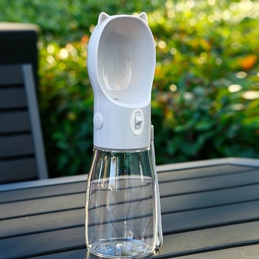 Grey 550 ml portable dog water bottle with drinking cup on a garden table